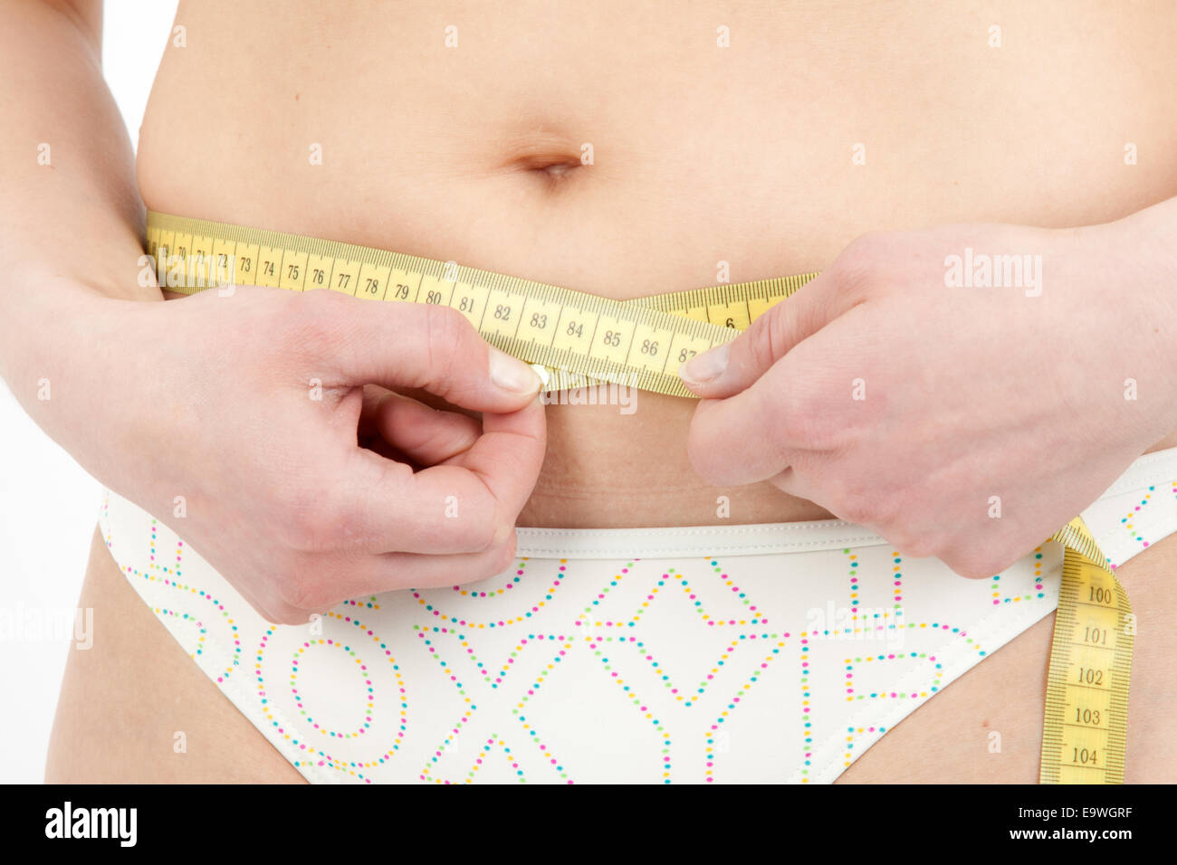 Young woman measuring her abdominal girth Stock Photo Alamy