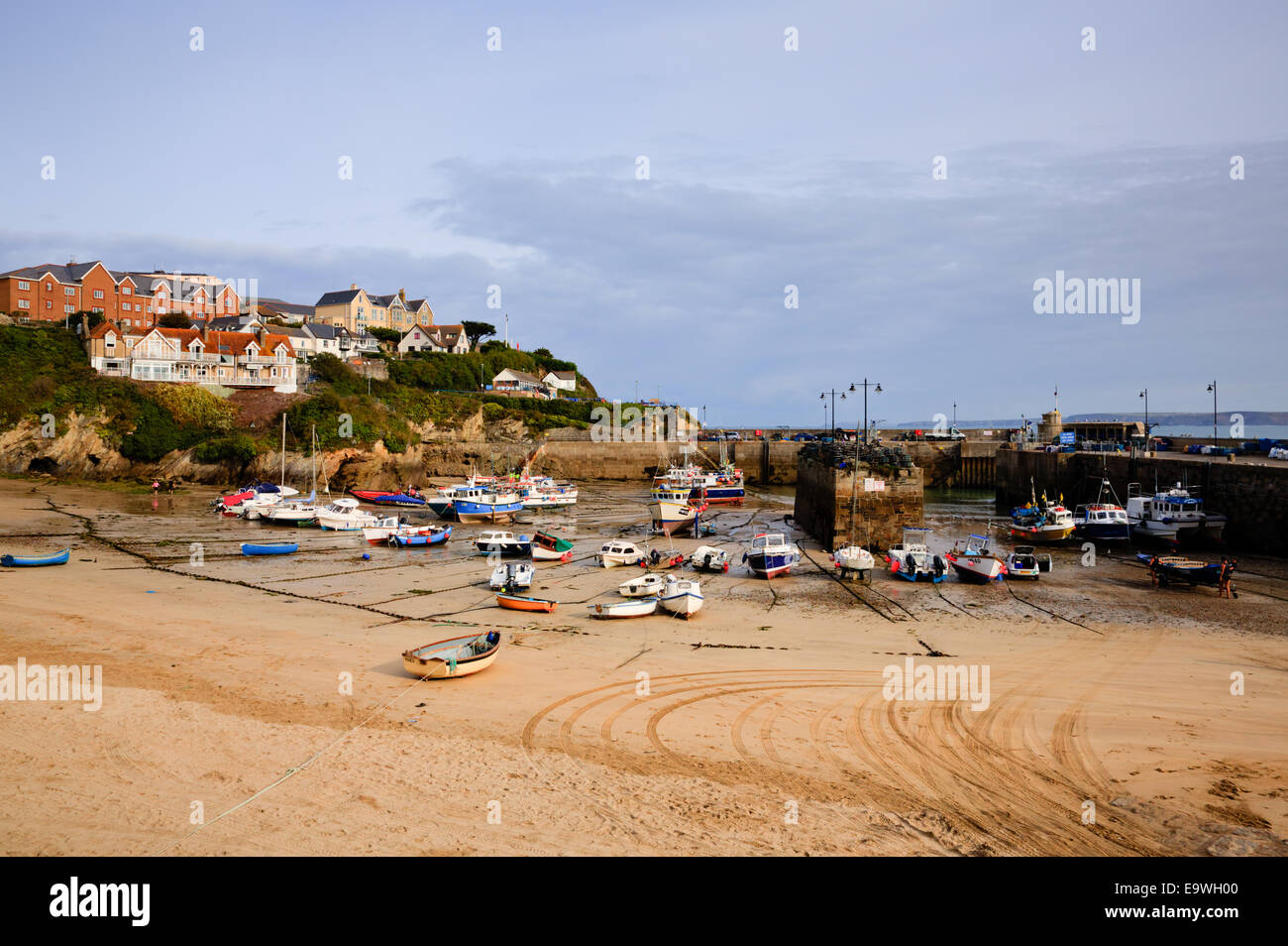 Newquay harbour North Cornwall England UK with boats and sandy beach and houses on hill Stock Photo