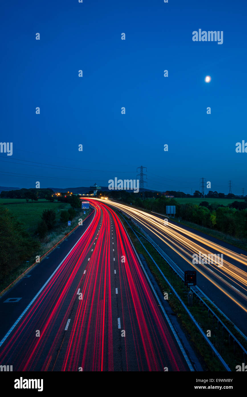 Full moon and light-trails of traffic on the M6 near Lancaster (Forton) services Lancashire Stock Photo