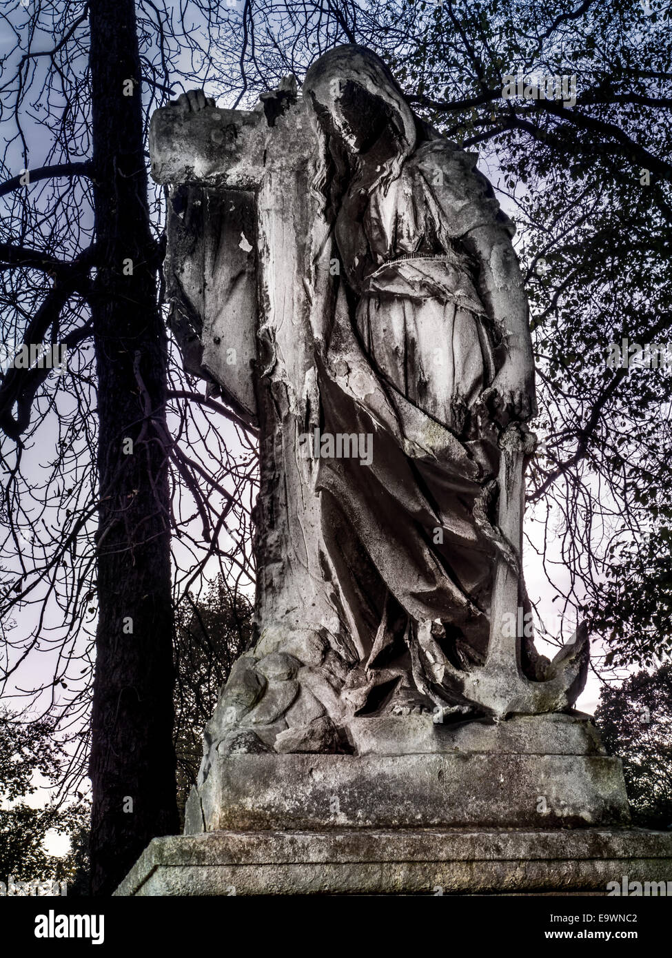 Stone statue of Jesus Christ carrying cross as a mourning statue on a tombstone Stock Photo