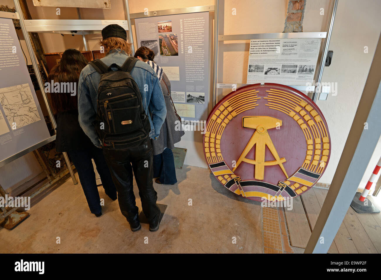 Dreilinden, Germany. 02nd Nov, 2014. Tourists visit the former command tower at the border checkpoint to West Berlin 'Checkpoint Bravo' in Dreilinden, Germany, 02 November 2014. To the right is the national emblem of the former German Democratic Republic . 09 November 2014 is the 25th anniversary of the Fall of the Berlin Wall. Photo: RALF HIRSCHBERGER/dpa/Alamy Live News Stock Photo