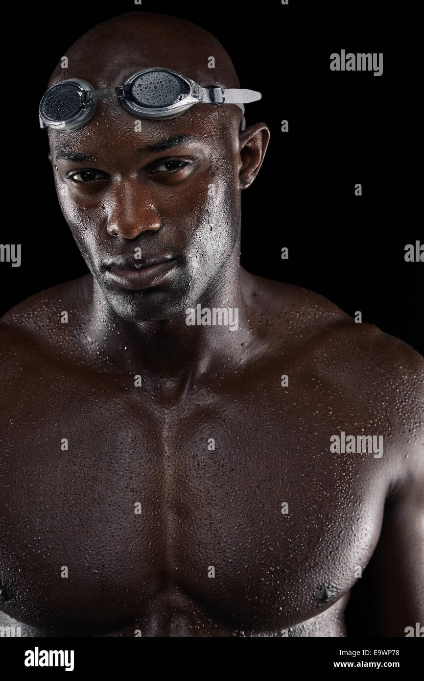 Determined swimmer with wet body looking at camera. Portrait of young Afro-American male athlete with muscular body. Stock Photo