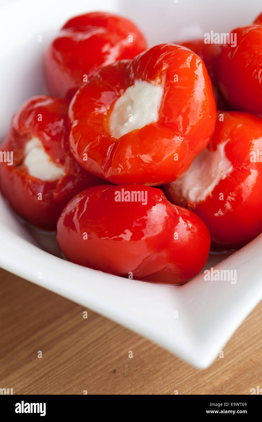 Cherry peppers stuffed with creamy cheese in olive oil. Stock Photo