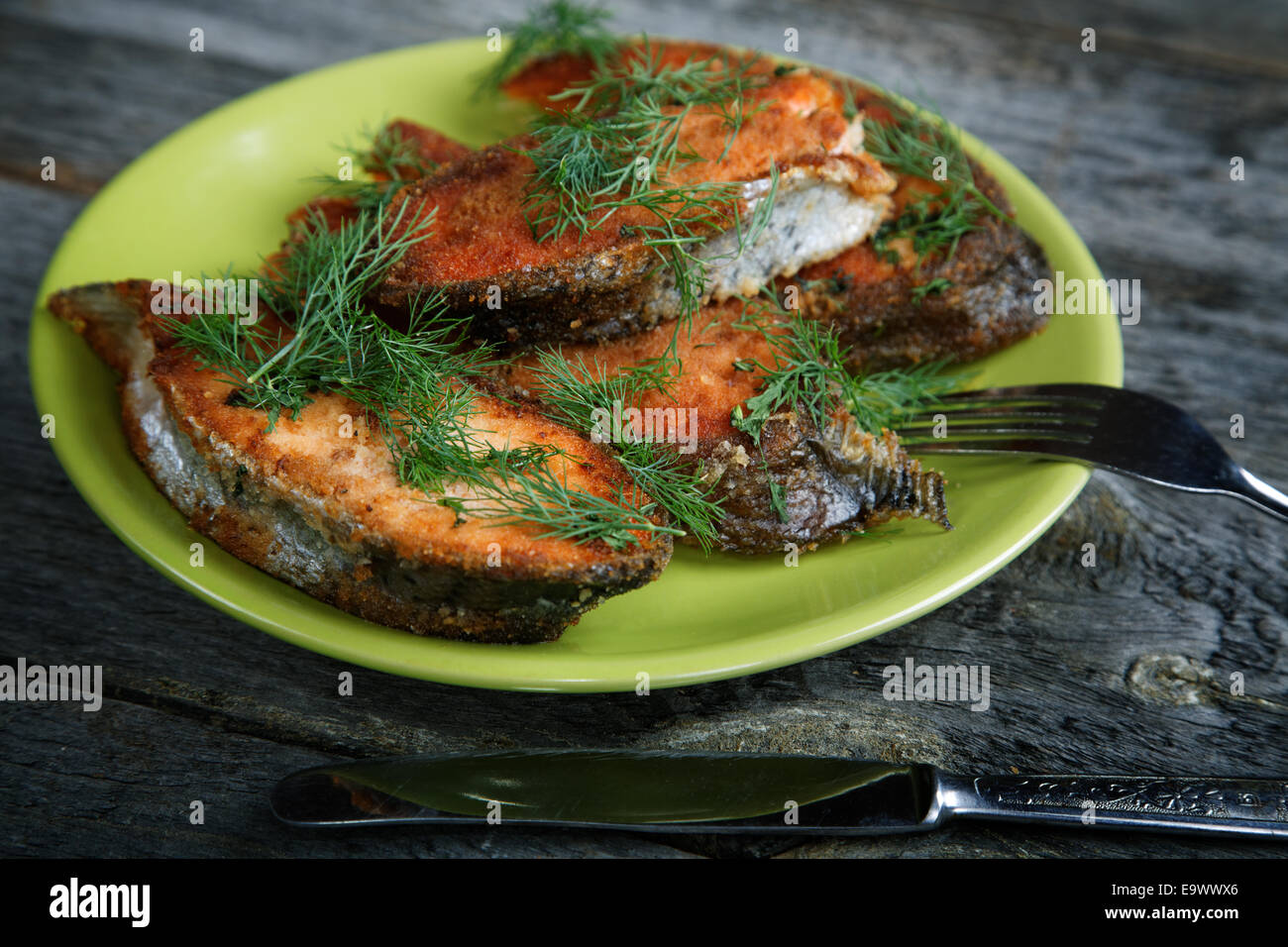 Plate with fried fish on a wooden table Stock Photo