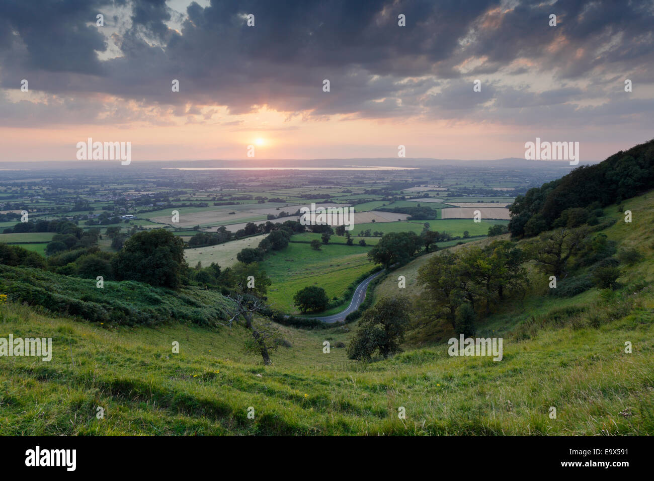 Winding Country Road at Coaley Peak, with views of the Severn Vale beyond. Gloucestershire, UK. Stock Photo