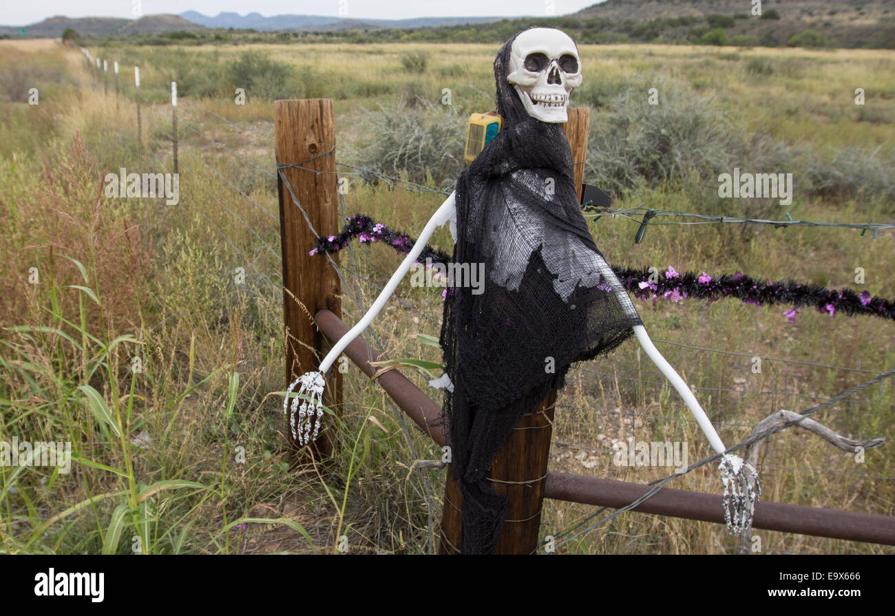 Masks used as Halloween decoration at ranch entrance in West Texas