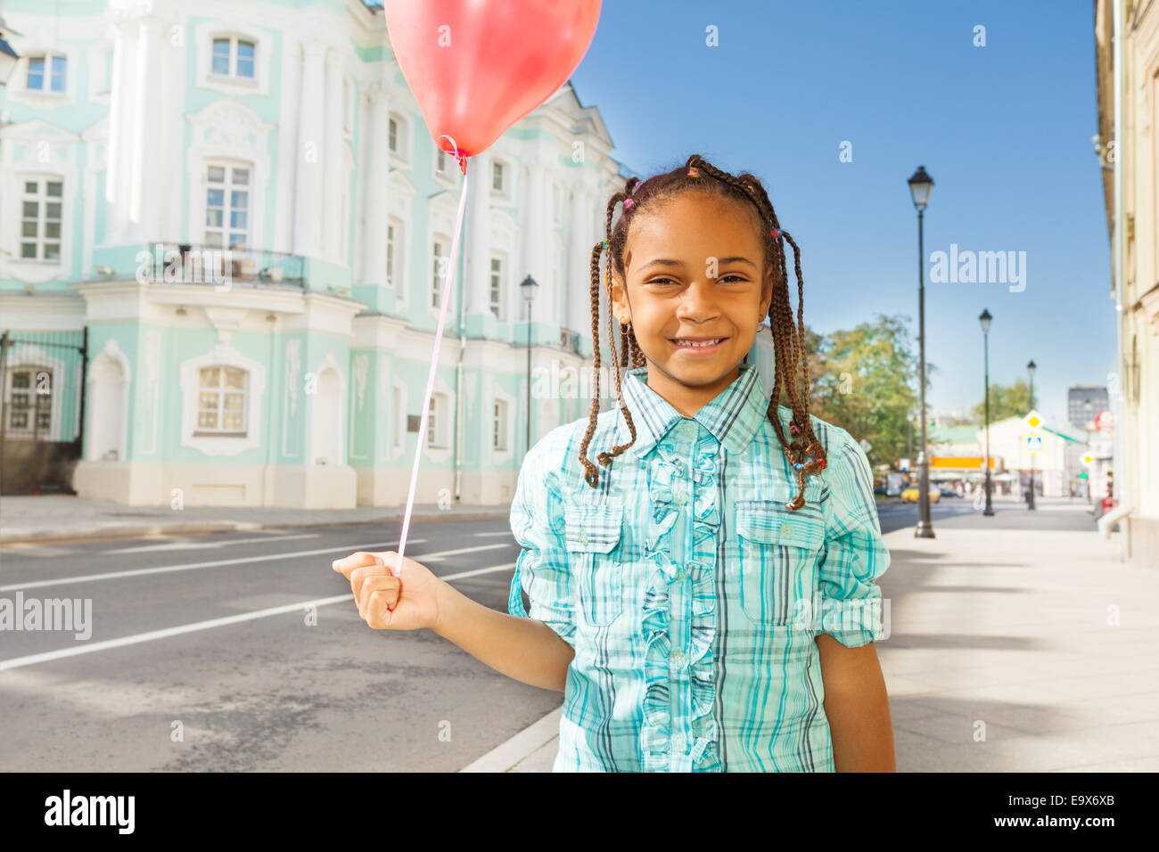 African girl with flying balloon stands on street Stock Photo Alamy