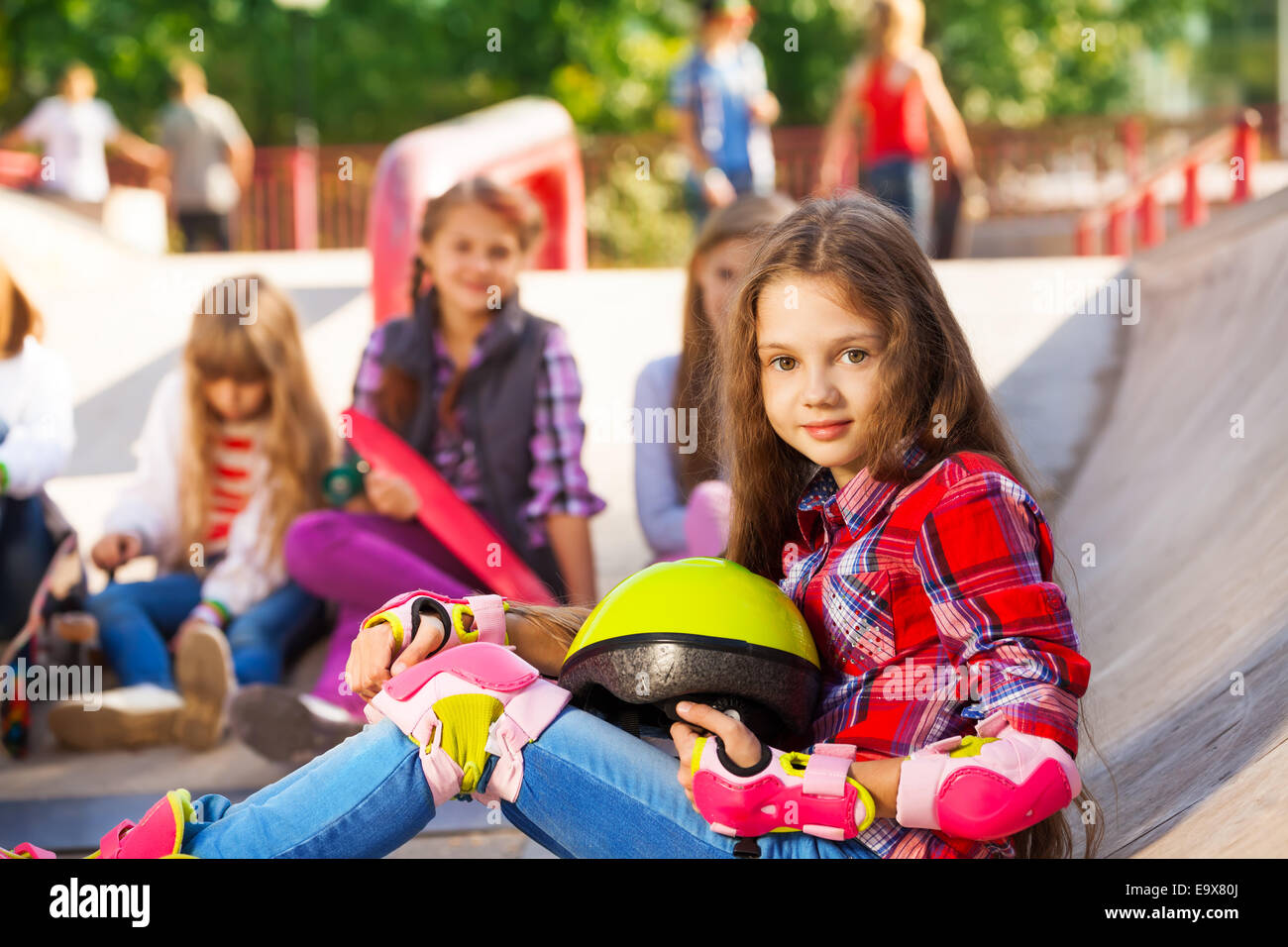 Girl holds helmet wearing inline skates sitting Stock Photo Alamy
