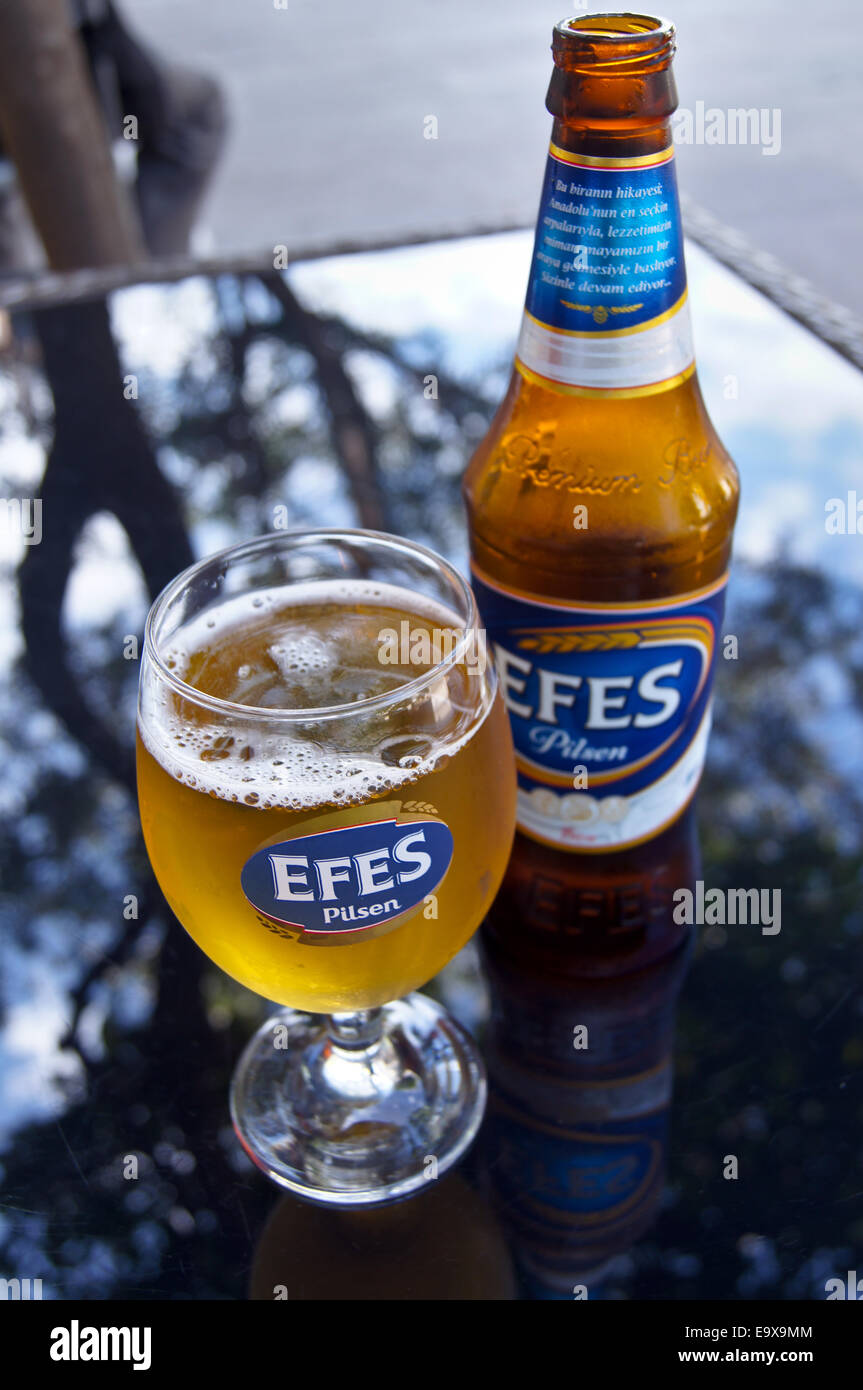 A glass and bottle of Efes Turkish beer,  Bodrum, Turkey, pub table drinks glasses Stock Photo