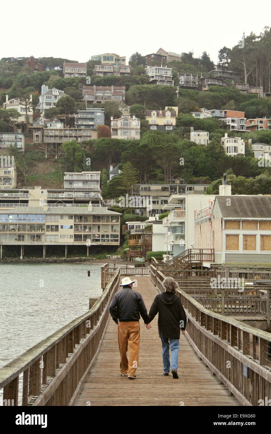 elderly couple walk hand in hand on Sausalito California pier Stock Photo