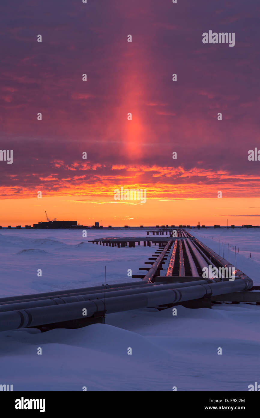 Colorful sunrise over Drill Site 9 and oil flow lines in the Prudhoe
