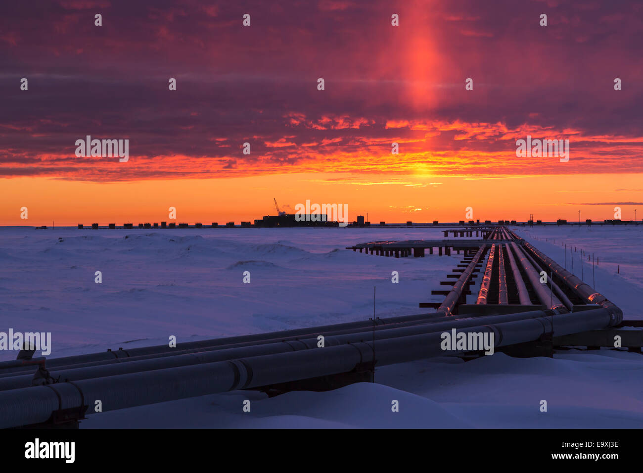 Colorful sunrise over Drill Site 9 and oil flow lines in the Prudhoe