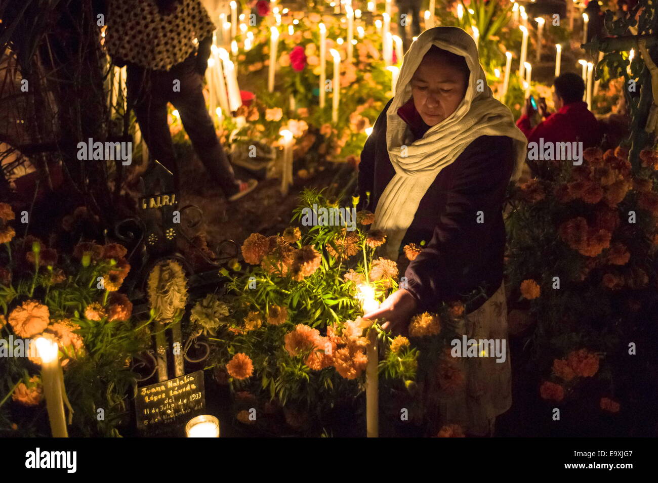 Oaxaca, Mexico. 2nd Nov, 2014. A woman leaves candles and flowers at the grave of her mother for Dia de Los Muertos in the town of Atzompa. © Nick St.Oegger/ZUMA Wire/ZUMAPRESS.com/Alamy Live News Stock Photo