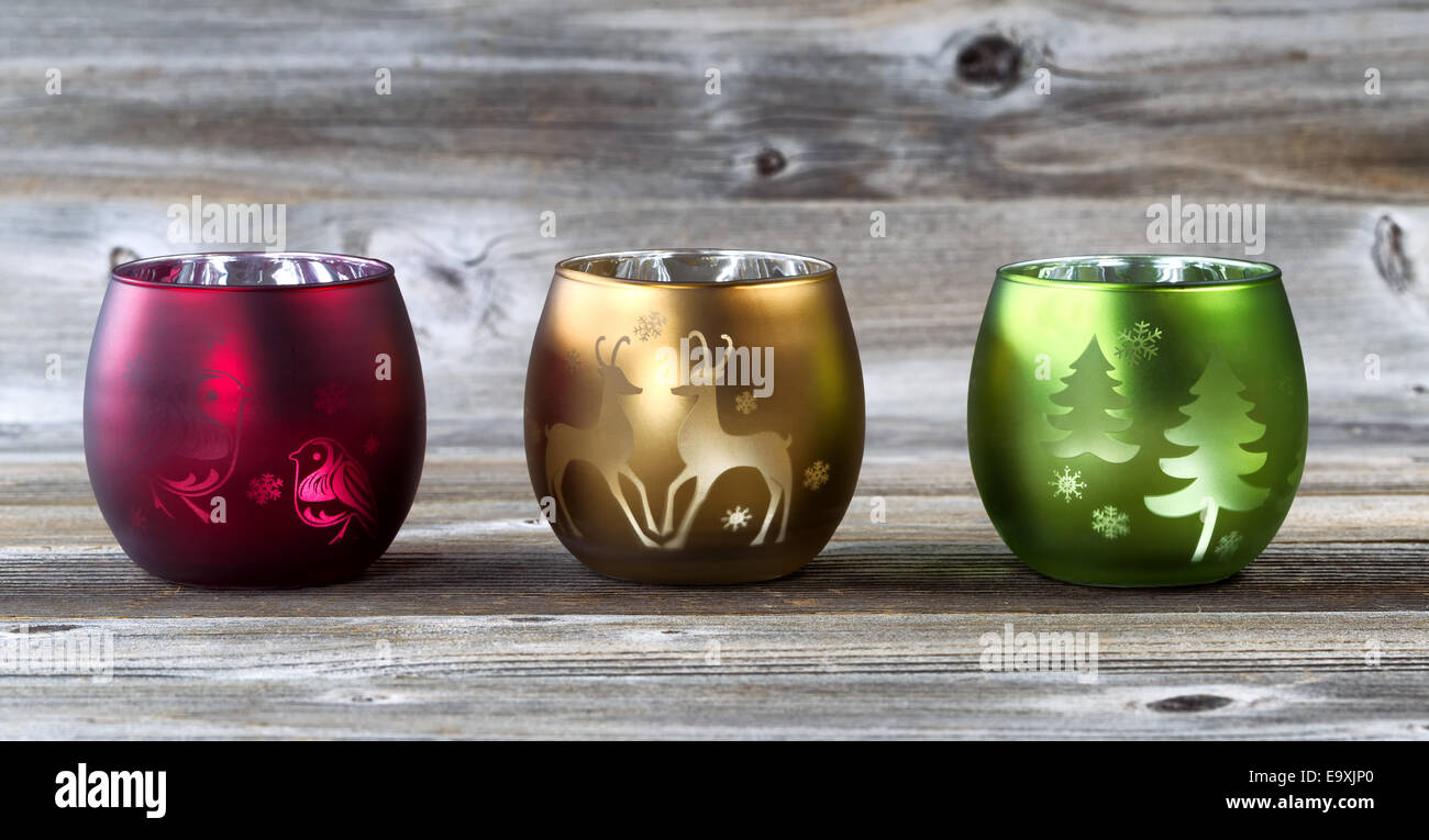 Bright holiday candle cup holders on rustic wood Stock Photo