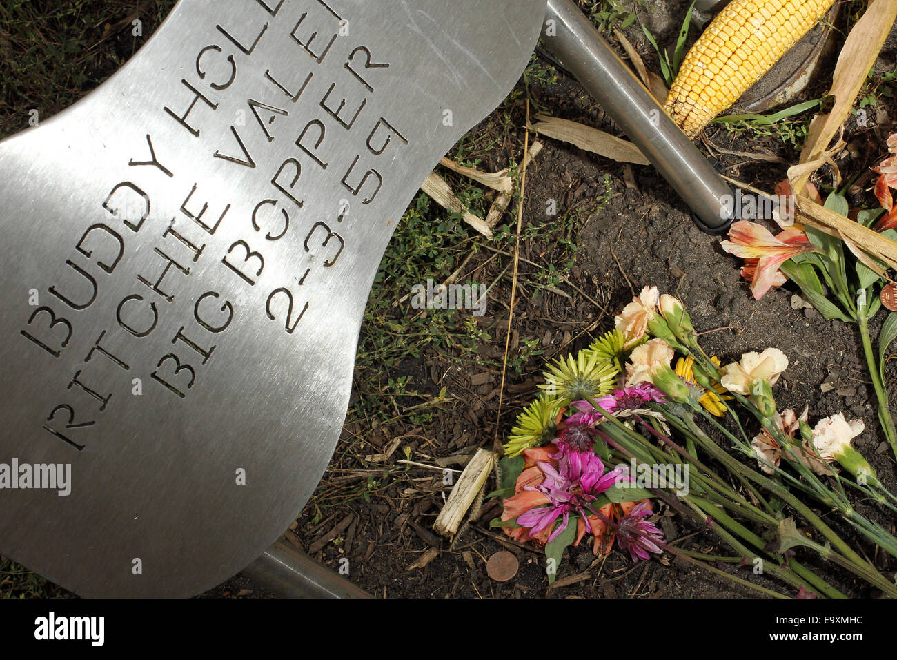 Clear Lake, IOWA, USA. 5th Oct, 2014. Flowers at a memorial at the spot where the plane carrying Buddy Holly, Ritchie Valens and J.P. ''The Big Bopper'' Richardson crashed killing all aboard on Feb. 3, 1959, North of Clear Lake, Iowa. The three young singers were in a single-engine aircraft flying in a light snowstorm in 1959 when the pilot apparently lost control. Holly decided to fly because his tour bus was having heating problems. © Kevin E. Schmidt/ZUMA Wire/Alamy Live News Stock Photo