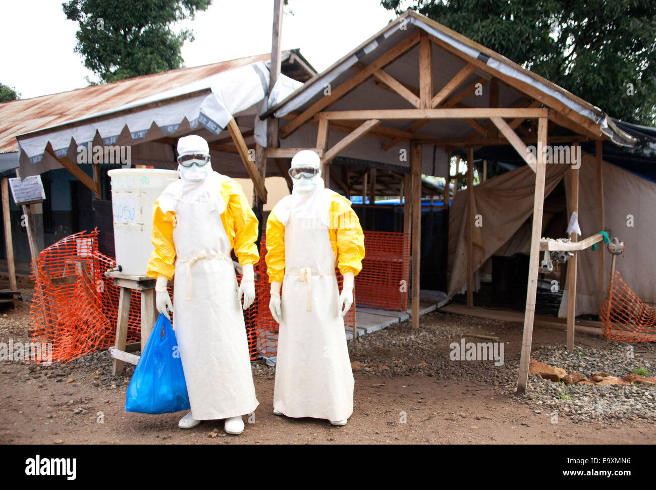 Gueckedou, Guinea. 16th Oct, 2014. Two medical doctors wear protective suits at the ebola treatment centre in Gueckedou, Guinea, 16 October 2014. Former ebola patients, who are immune after contracting and surviving the ebola virus, are now organising help initiaitves for people affected by the ebola virus to help themselves. While some are taking care of children who contracted ebola, others are involved in the struggle against stigmatisation, information campaigns or are taking care of patients. Photo: Kristin Palitza/dpa/Alamy Live News Stock Photo