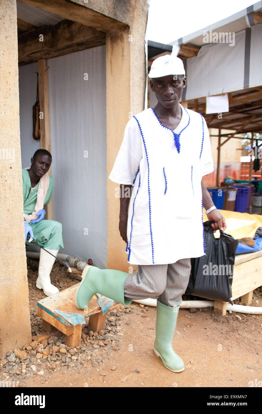 Gueckedou, Guinea. 16th Oct, 2014. A staff member is being disinfected as he leaves the ebola treatment centre in Gueckedou, Guinea, 16 October 2014. Former ebola patients, who are immune after contracting and surviving the ebola virus, are now organising help initiatives for people affected by the ebola virus to help themselves. While some are taking care of children who contracted ebola, others are involved in the struggle against stigmatisation, information campaigns or are taking care of patients. Photo: Kristin Palitza/dpa/Alamy Live News Stock Photo
