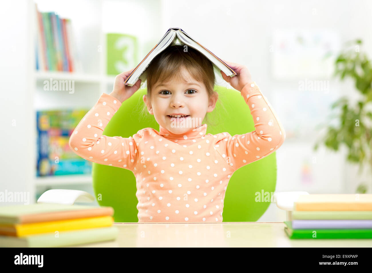 preschooler kid girl with book over her head Stock Photo - Alamy