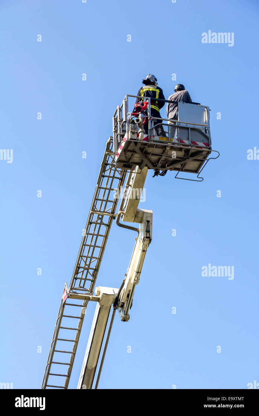 Ladder truck with firefighters and blue sky background Stock Photo