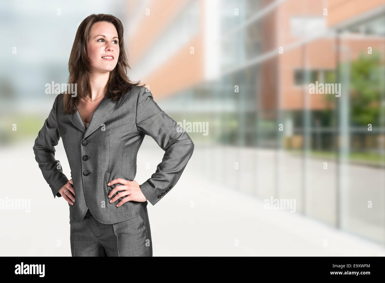 Business woman in gray suit in front of an office building Stock Photo