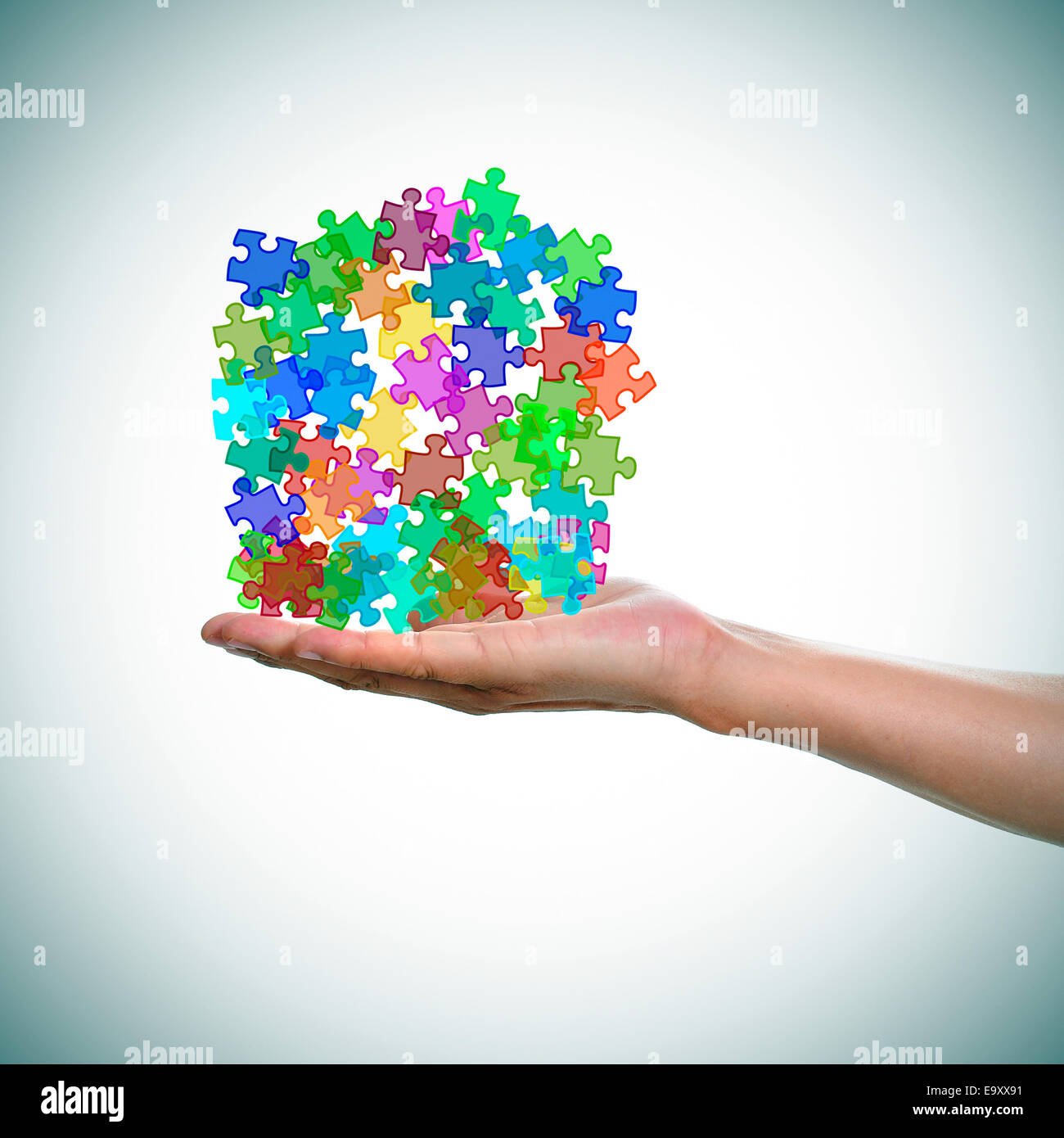 a man hand with a pile of puzzle pieces of different colors as the symbol for the autism awareness Stock Photo