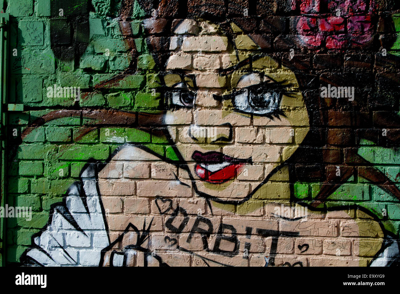 graffiti Berlin wall bricks womans face orbit Stock Photo