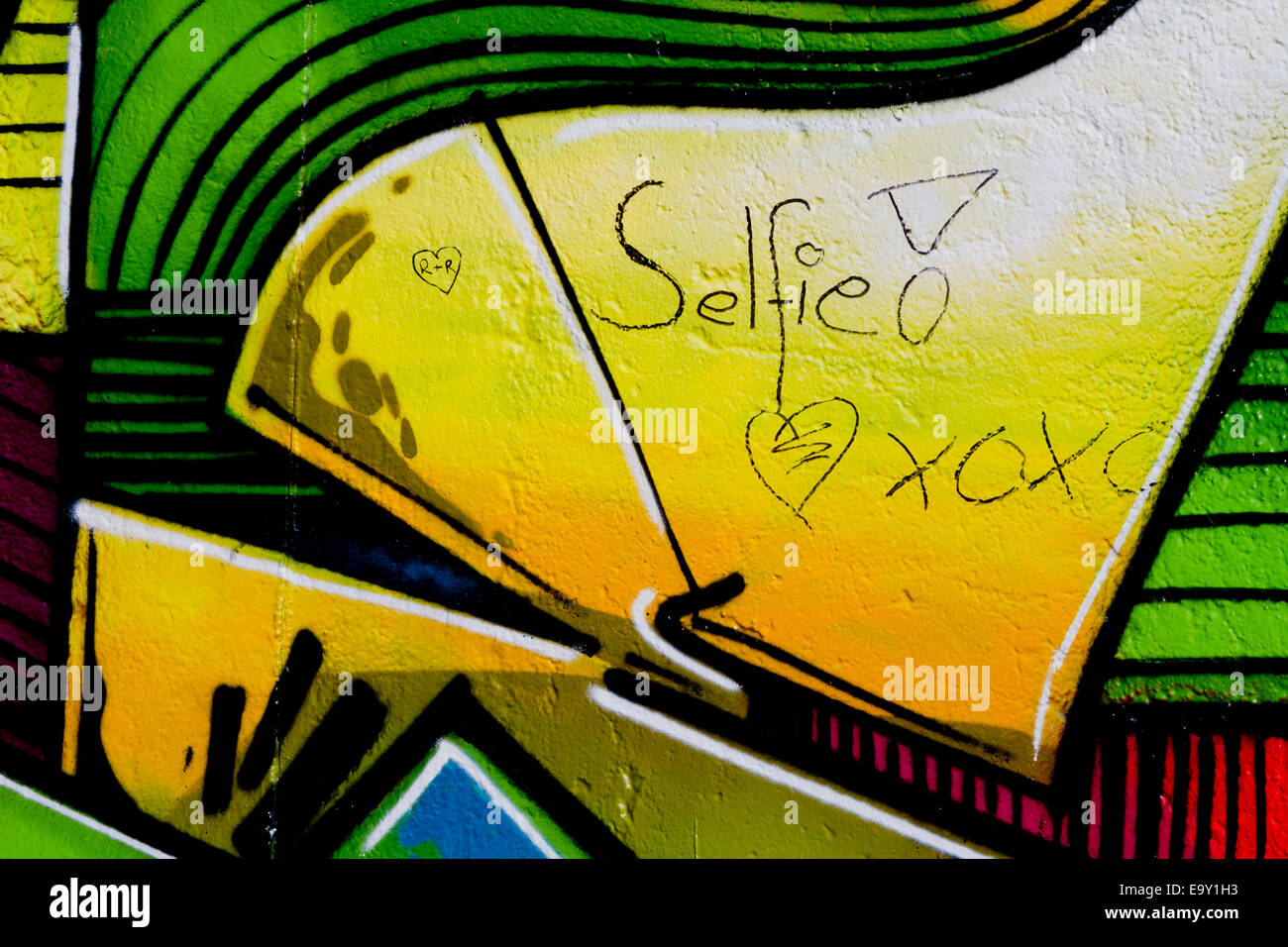 Berlin wall graffiti colourful selfie kisses heart Stock Photo