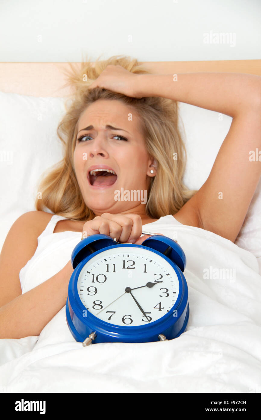 Sleeplessness, clock at night. Woman cannot sleep. Stock Photo