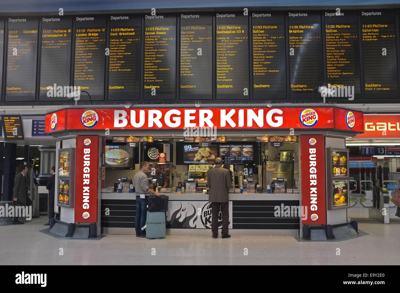 A burger king shop under the departure board of Victoria Station Stock