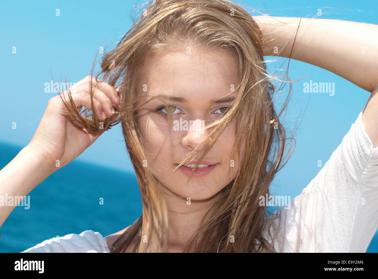 Beautiful blond girl with long hair against the blue sea Stock Photo ...