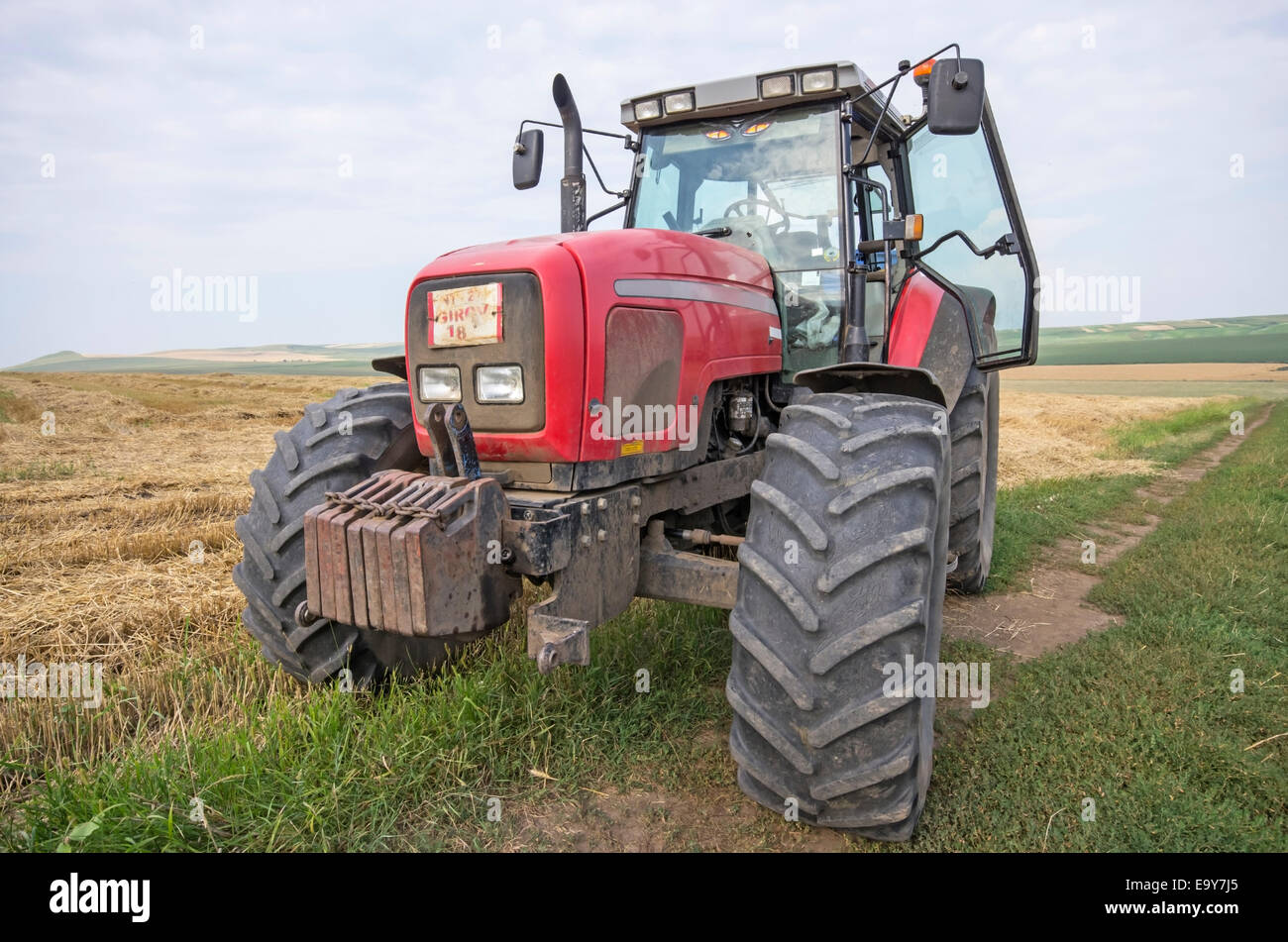 Red agriculture tractor on a field in summer Stock Photo Alamy