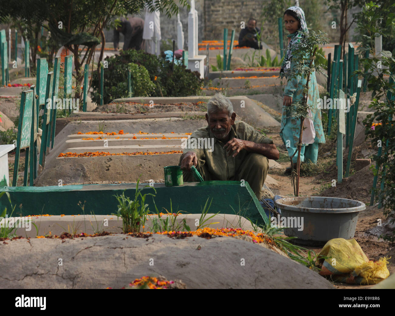 Pakistani people cleans their loved ones graveyard on 9th Muharram at