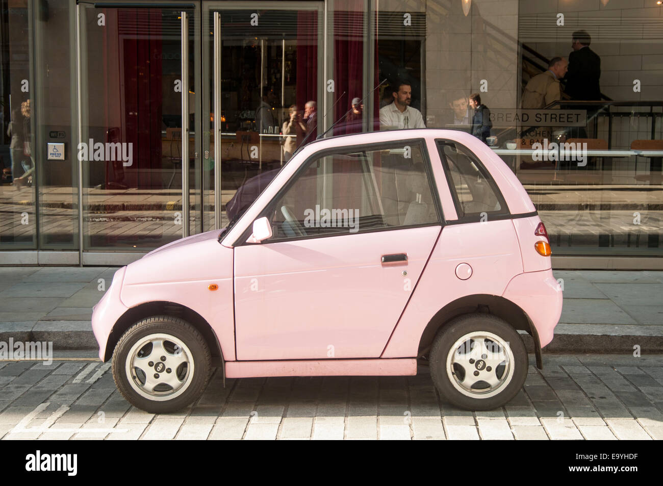 pink electric G-Wiz car parked in a London street Stock Photo