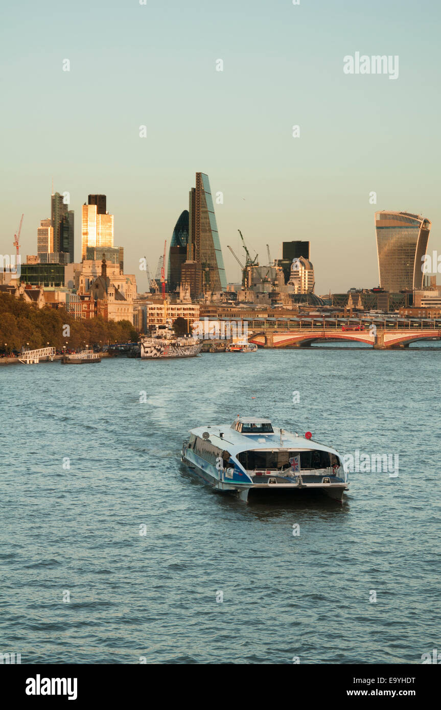 a sightseeing cruise on the River Thames with the city of London in the distance Stock Photo