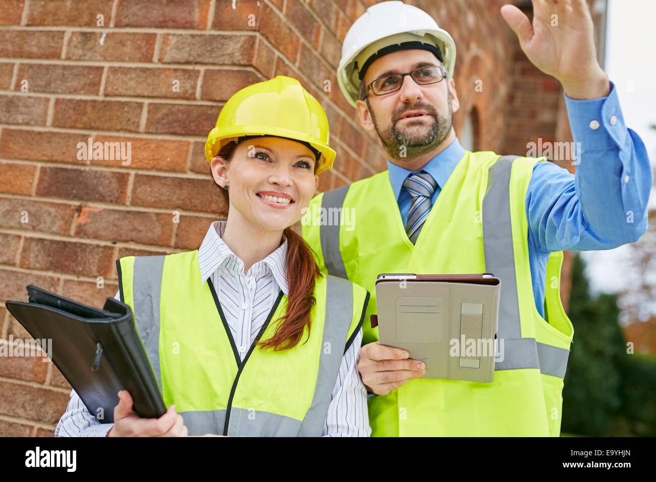 Architects discussing plans at a building site Stock Photo