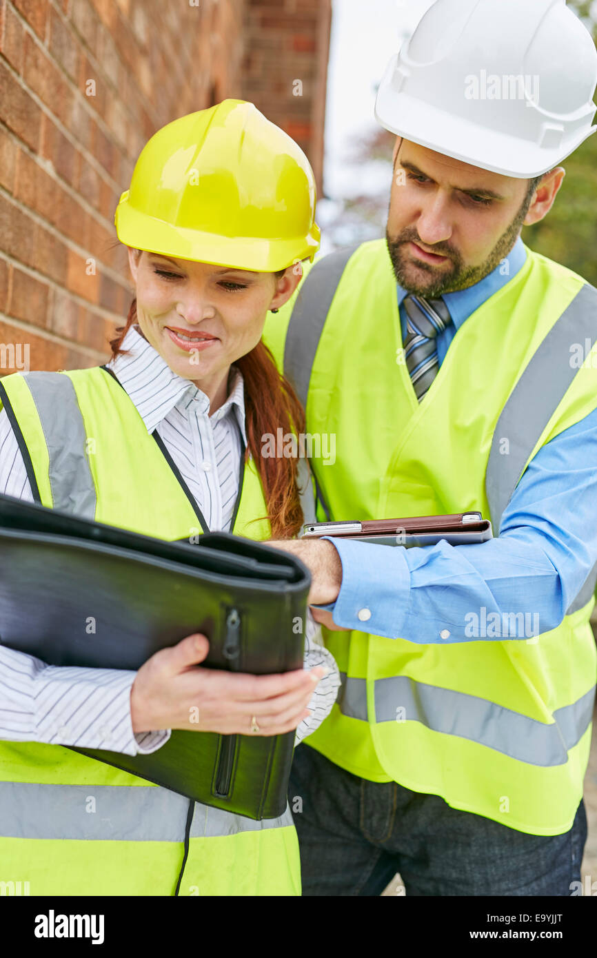 Architects discussing plans at a building site Stock Photo