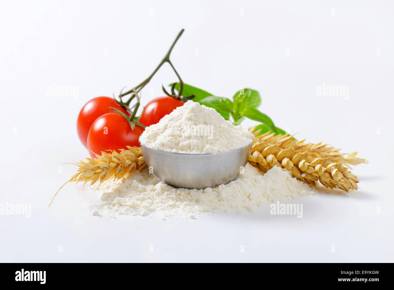 Bowl of finely ground flour, wheat ears and fresh tomatoes - still life Stock Photo