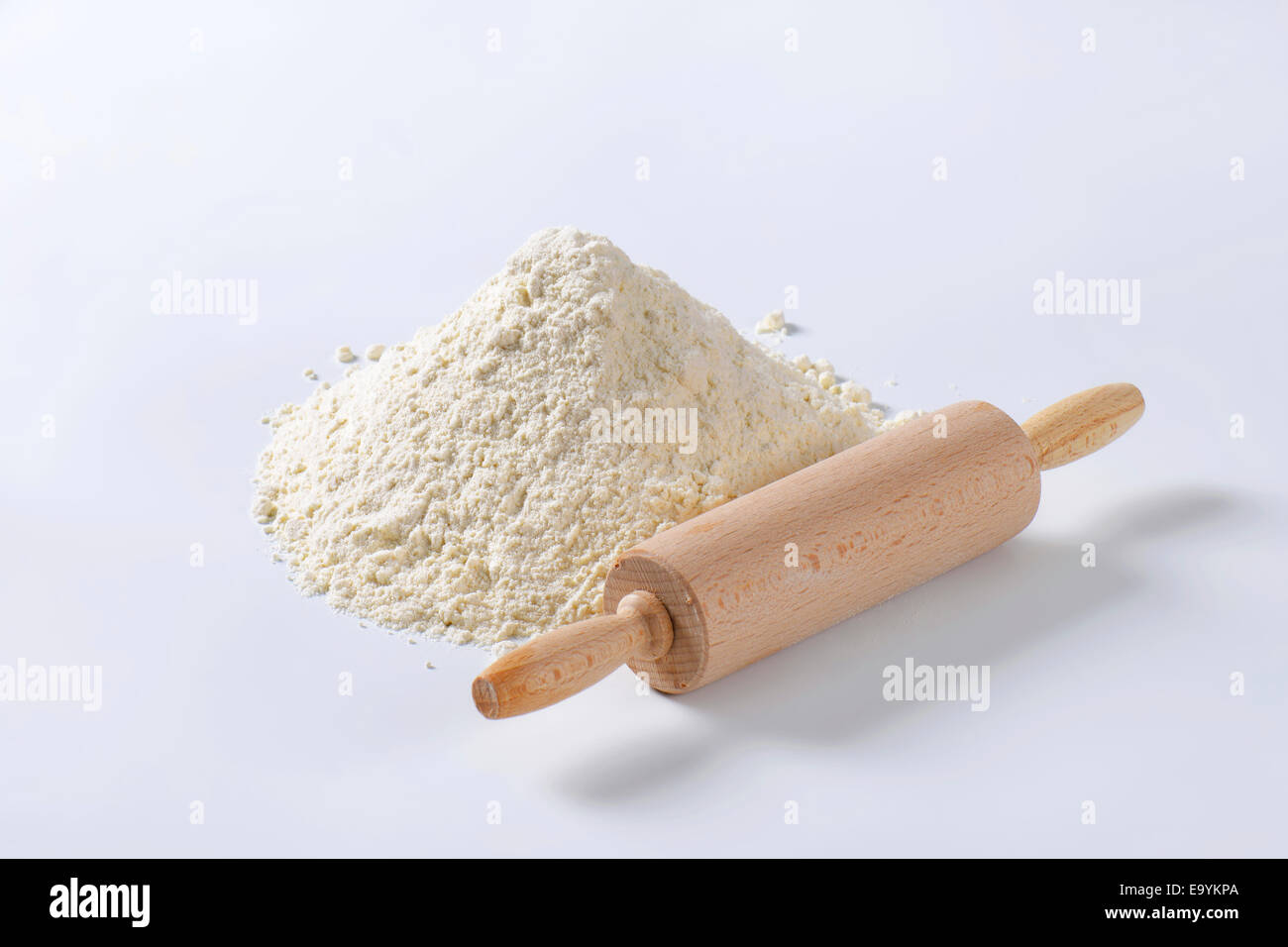 Wooden 'roller' type rolling pin and pile of finely ground flour Stock Photo
