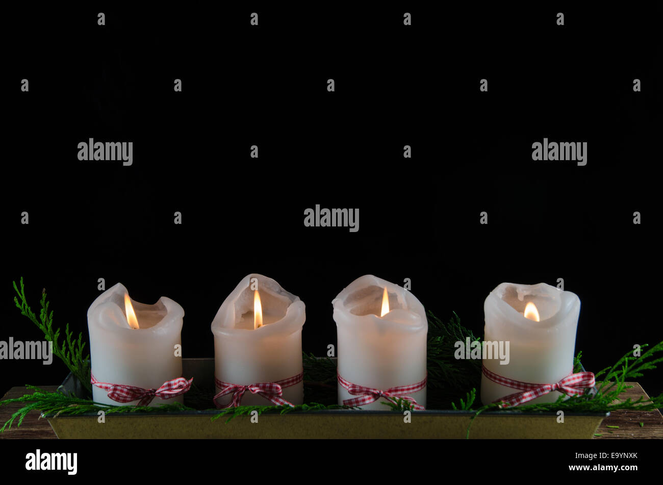 Four burning advent candles at a black background Stock Photo Alamy
