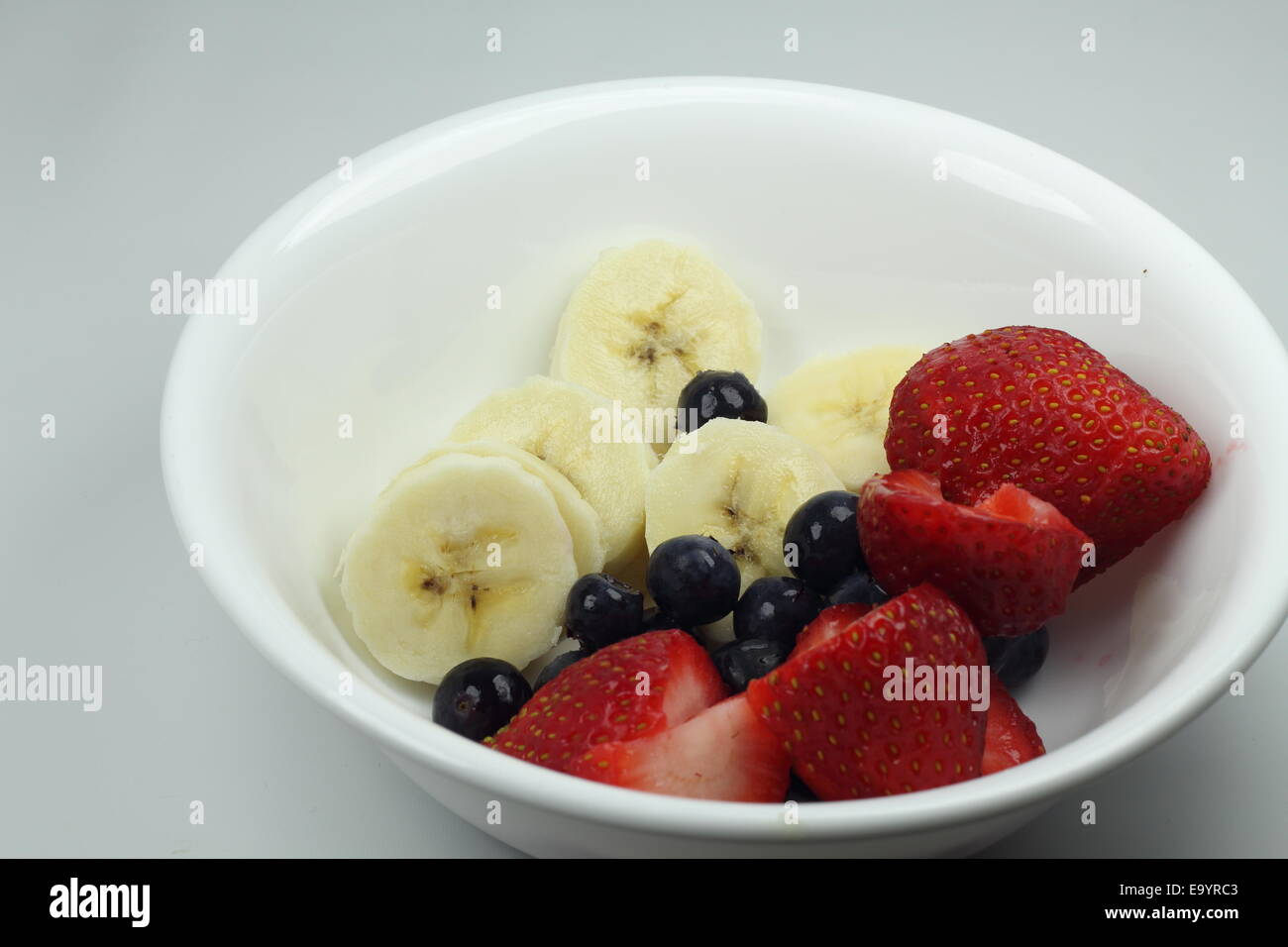 Fruit banana, blueberries and strawberries in a white bowl Stock Photo Alamy