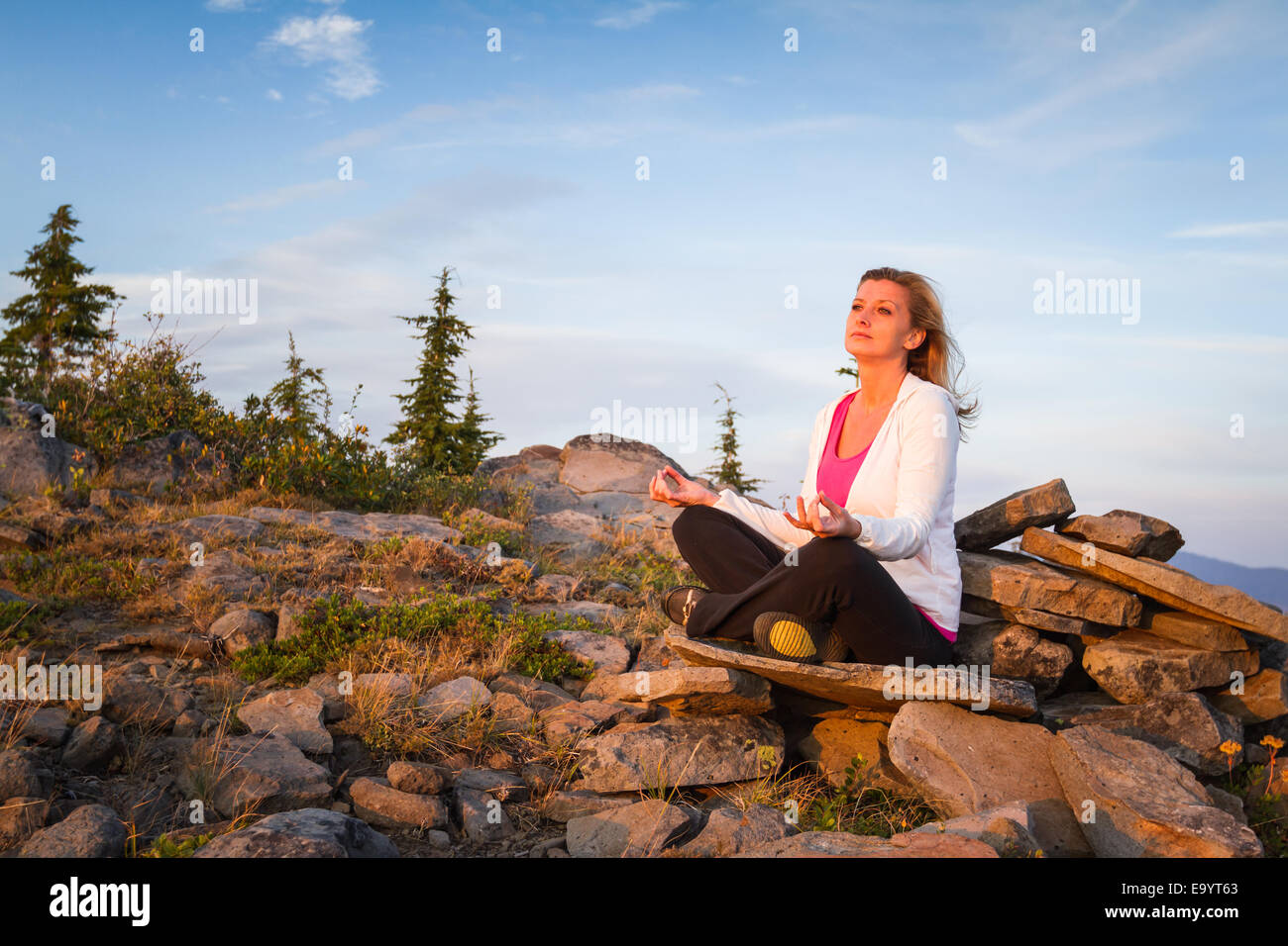beautiful woman meditating on the top of a mountain Stock Photo - Alamy