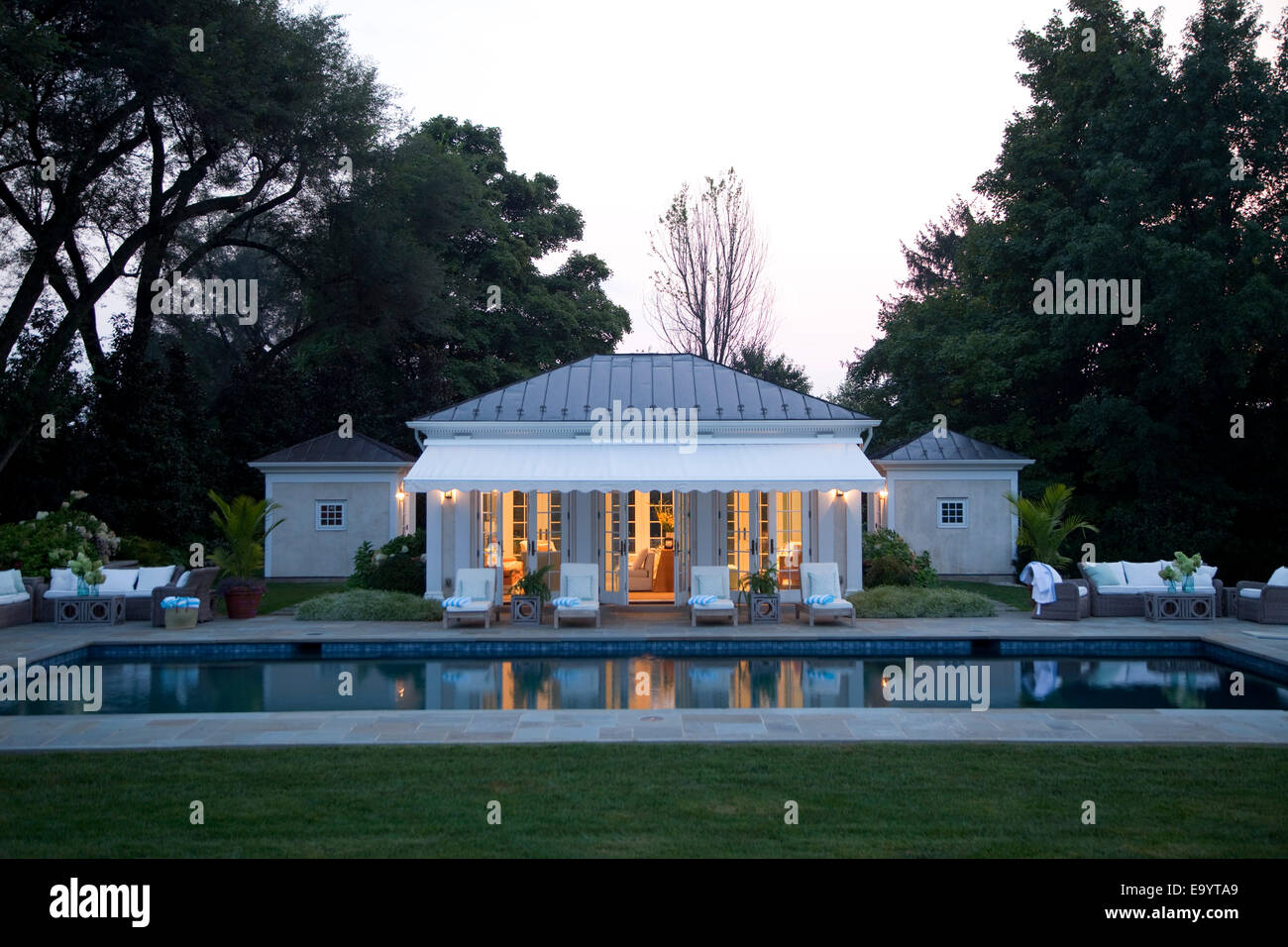 Swimming pool and pool house in early evening. Stock Photo