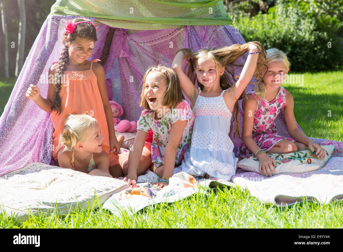 Five girls playing in garden teepee Stock Photo
