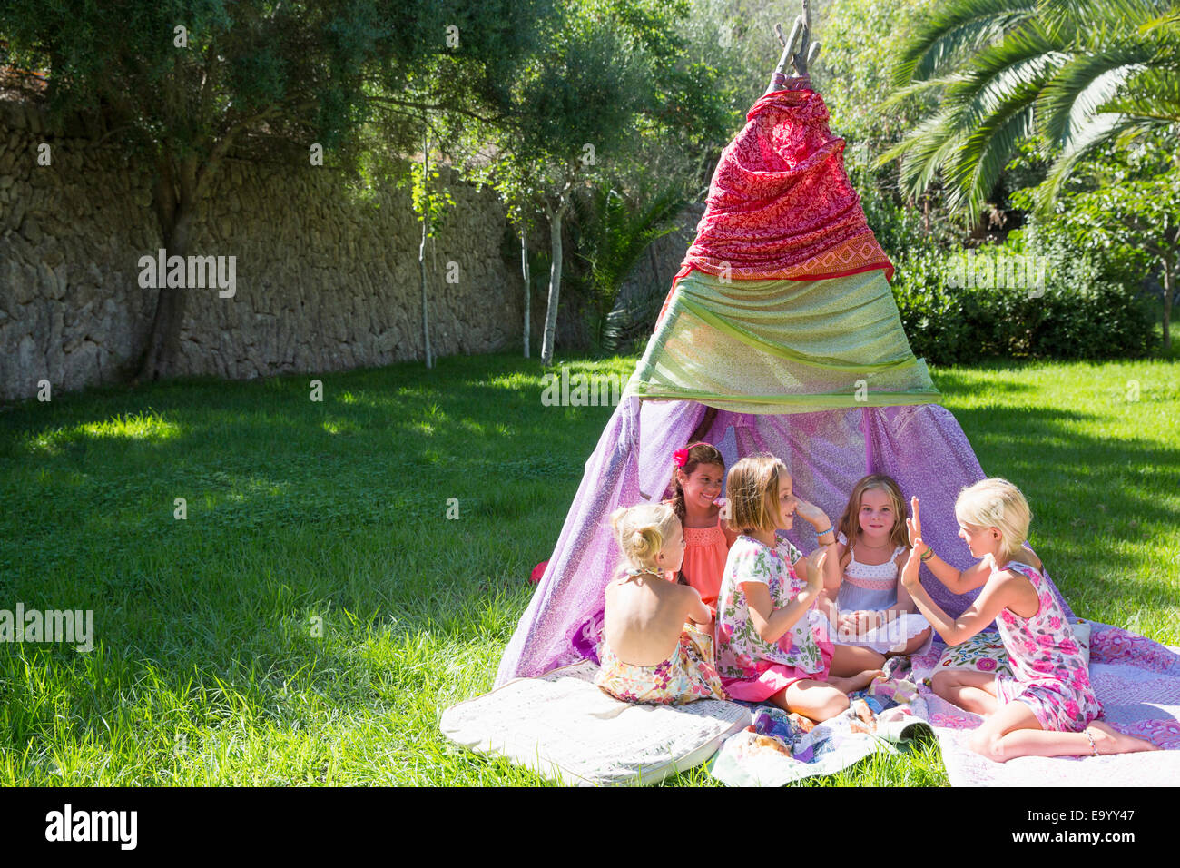 Five girls playing clapping games in front of teepee Stock Photo