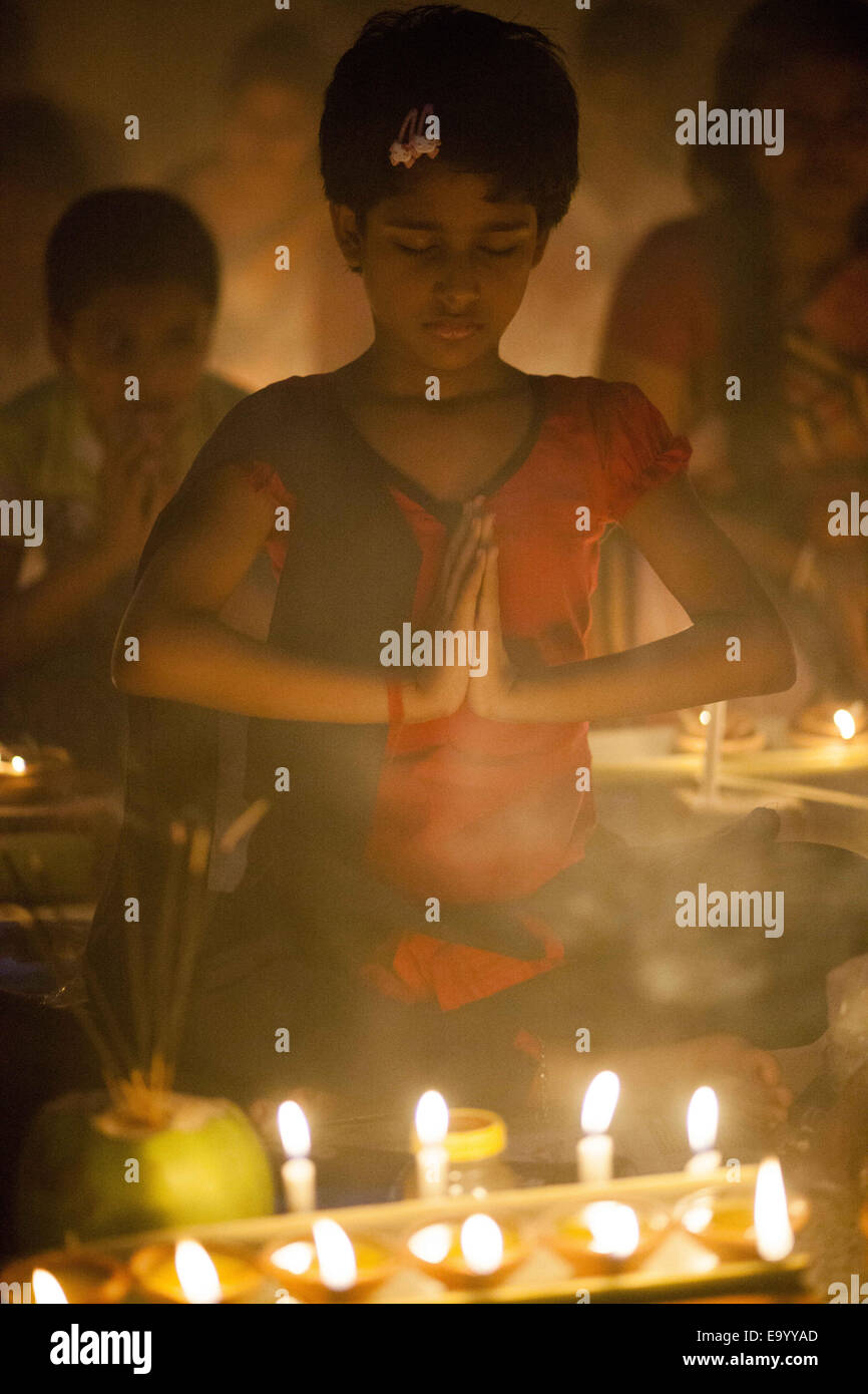 Narayangonj, Bangladesh. 4th Nov, 2014. People of Hindu Community (Bangladeshi) celebrating 'Rakher Upobas''a culture in every Bengali month Kartik. It's a fast day for keeping safe all of own family members from all kinds of black issues. Hindu Man and Women are celebrating this ritual festival by lighting lamps and candles from just sunset with some gift (fruits, sweets, coconut, cow milk etc.) for their belief 'Baba Loknath'' Hindus one of the God. And every fans keep themselves fasting until the lamps burn-out. Credit:  ZUMA Press, Inc./Alamy Live News Stock Photo