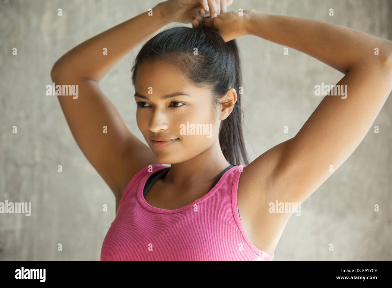 Woman tying up hair Stock Photo