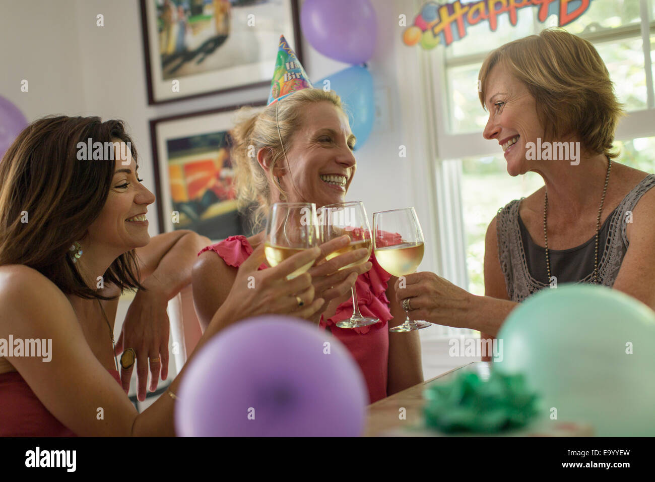Three mature women toasting with wine glasses Stock Photo