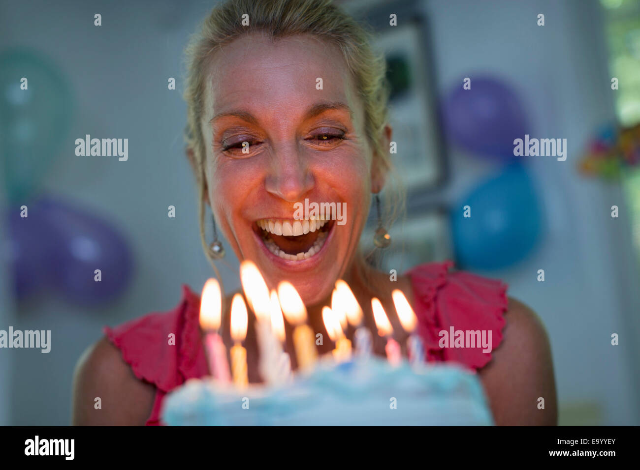 Mature woman holding birthday cake with candles Stock Photo - Alamy
