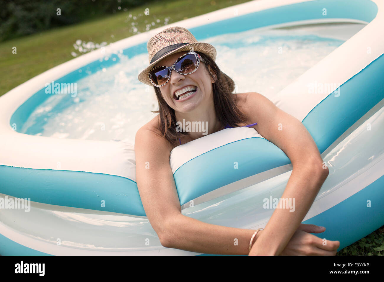 Mature woman in paddling pool, splashing water Stock Photo Alamy