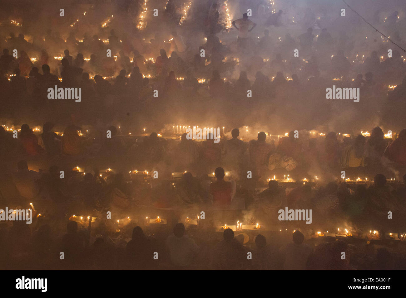 Narayangonj, Bangladesh. 4th Nov, 2014. People of Hindu Community (Bangladeshi) celebrating "Rakher Upobas""a culture in every Bengali month Kartik. It's a fast day for keeping safe all of own family members from all kinds of black issues. Hindu Man and Women are celebrating this ritual festival by lighting lamps and candles from just sunset with some gift (fruits, sweets, coconut, cow milk etc.) for their belief "Baba Loknath"" Hindus one of the God. And every fans keep themselves fasting until the lamps burn-out. Credit:  ZUMA Press, Inc./Alamy Live News Stock Photo